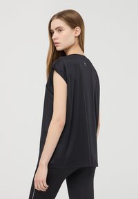 T-shirt nera a maniche corte, realizzata in un tessuto morbido, con una vestibilità comoda e un piccolo dettaglio del logo sul collo a retro.