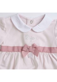 Robe rose clair avec un col blanc, dotée d'un logo brodé et d'une taille rose côtelée avec un détail en forme de nœud. Fermeture à boutons à l'arrière.