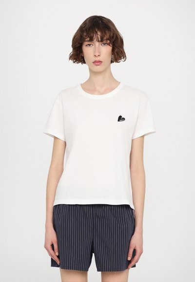 White short-sleeve t-shirt with a rounded neckline, featuring a small black heart logo with "ZADIG" on the left chest area.