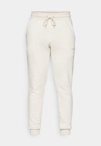White sweatpants made from soft fabric, featuring an elastic waistband with drawstring, two side pockets, and fitted cuffed ankles.