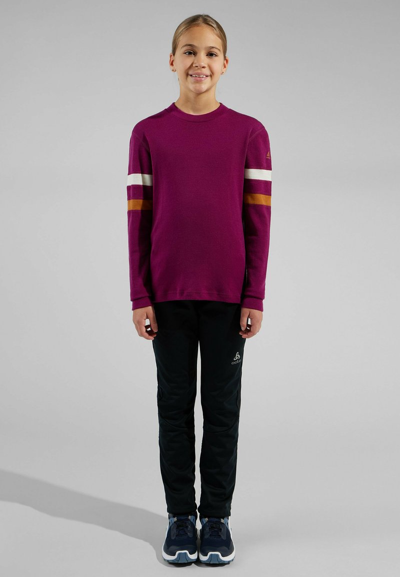 Purple sweatshirt with horizontal stripes in white and orange, paired with black pants and navy sneakers. Smooth texture, casual fit.