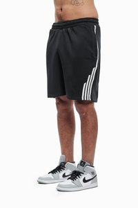 Schwarze Sportshorts mit weißen Seitenstreifen, elastischem Bund und einem Logodetail. Kombiniert mit grauen und weißen High-Top-Sneakern.