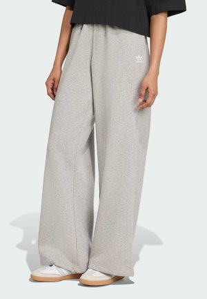 Pantalones de chándal gris claro con un corte holgado, hechos de material suave. Presentan un logotipo bordado en blanco en el lado izquierdo y piernas rectas.