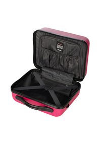 Valigia rigida rosa con interno nero, dotata di cinghie elastiche, tasche per l'organizzazione e chiusura a cerniera.