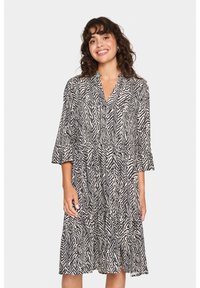 Schwarz-weißer Zebra-Print Midi-Kleid mit V-Ausschnitt, Dreiviertelärmeln und ausgestelltem Saum, aus leichtem Stoff gefertigt.