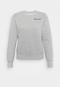 Sudadera gris con cuello redondo, mangas largas y dobladillo ajustado. Presenta un pequeño logo en azul marino de "Champion" en el pecho. Textura suave.