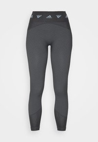 Black athletic leggings with a textured ribbed pattern, high waist, and logo accents at the waistband. Tight-fitting design throughout.