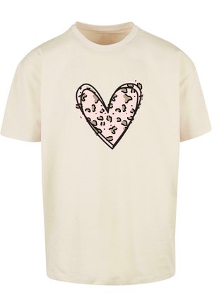 Beige pamut póló, rózsaszín szív mintával, leopárd mintázattal, fekete körvonalazással. Rövid ujjú, kerek nyakkivágású.