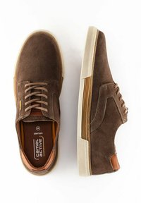 Brune ruskind sneakers med en tekstureret stofoverdel, snørebåndsdesign, kontrastfarvede tan-detaljer og en hvid gummisål. Brandlogoet er synligt indeni.