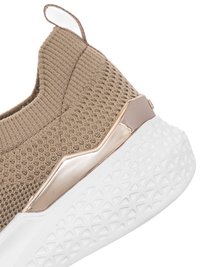 Close-up of beige knitted slip-on sneaker with white textured sole and metallic rose gold heel accent.