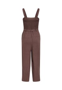 Combinaison marron sans manches avec larges bretelles, corsage smocké, ceinture à la taille et pantalon droit.
