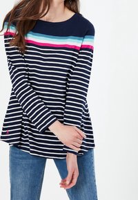 Marineblauw en witte gestreepte langemouwen top met kleurrijke horizontale strepen over de borst en een roze logo-accent aan de zoom.