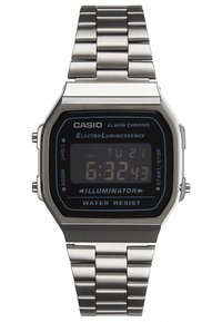 Montre numérique Casio avec bracelet en acier inoxydable. Le cadran noir affiche l'heure et le jour, possède des boutons sur le côté et est étanche.