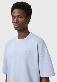 Lichtblauw oversized t-shirt van katoen, met een ronde halslijn en geborduurd "SAINT LAURENT LONDON" logo op de borst.