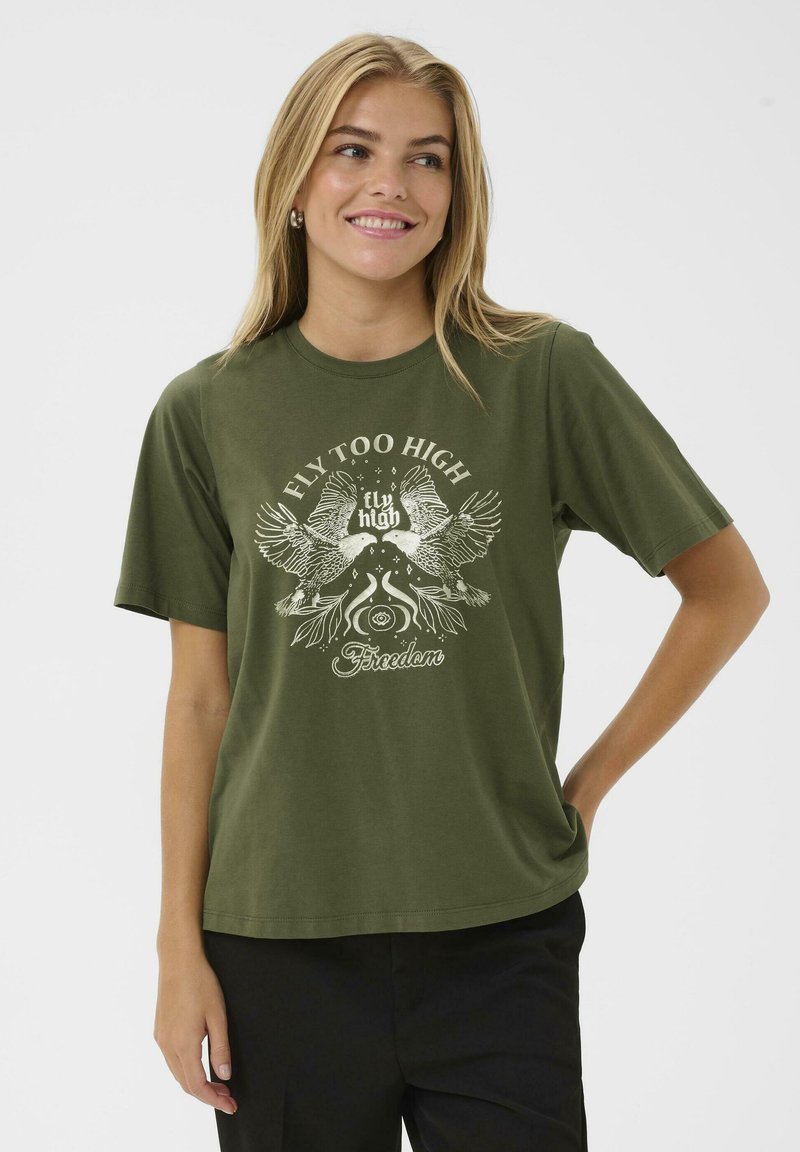 T-shirt en coton vert olive à manches courtes, avec un design graphique blanc de oiseaux et le texte "FLY TOO HIGH" et "Liberté."