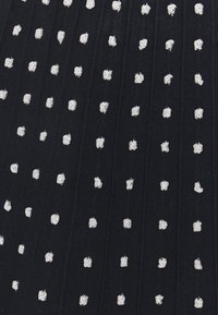 Tissu noir avec des petits points blancs texturés, uniformément espacés et disposés en lignes verticales.