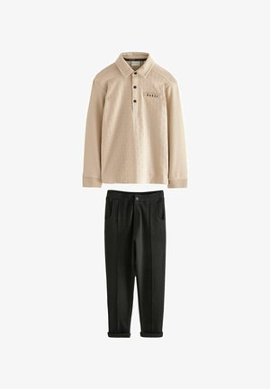 Beež pikkade varrukatega polo-särk tekstuuriga mustriga ja mustade nuppudega, kombineeritud mustade pükstega, millel on istuv vöökoht ja küljetaskud.