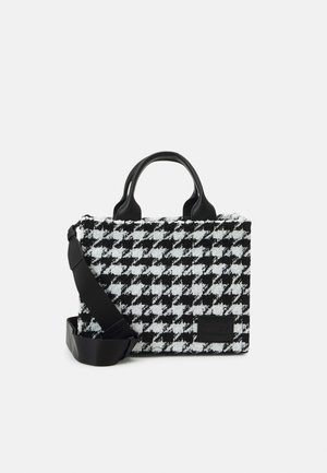 Černobílá kabelka s vzorem pepito, dvěma krátkými rukojetěmi a odnímatelným černým ramenním popruhem na bílém pozadí.