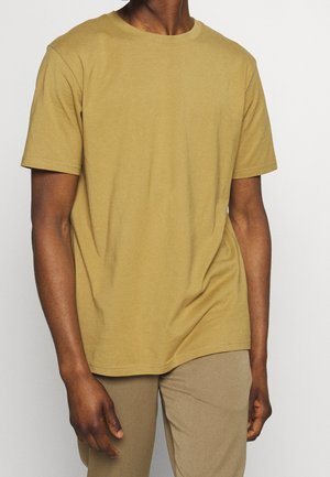 Short-sleeve, crew-neck t-shirt in mustard yellow, made of soft cotton, featuring a relaxed fit and smooth texture.