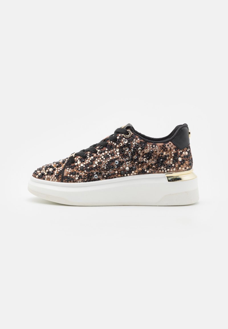Baskets imprimé léopard noir et marron avec lacets noirs, décorées de sequins brillants, semelle blanche épaisse et accent métallique doré au talon.