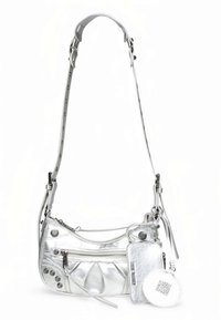 Zilverkleurige metallic crossbodytas met een gebogen vorm, textuurstrepen, ritssluitingen en drukknopaccenten. Inclusief een afneembaar tasje.