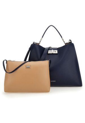 Stor navy håndtaske med tophåndtag og sølvlås ved siden af en mindre tan crossbody taske med lynlås og justerbar rem.