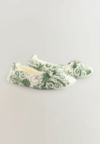 Lamedega jalatsid roheline lillemuster valgel taustal, ees on kaaridetail ning pehme tekstuuriga kangas.