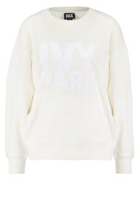 Sweat-shirt couleur crème à manches longues, col en V et coupe ample. Présente un grand logo blanc "IVY PARK" sur le devant. Matière en mélange de coton.