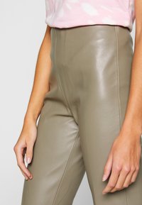 Hoge taille, beige leren broeken met een gladde textuur en een getailleerd ontwerp. Voorzien van zijnaad en een elegante afwerking.