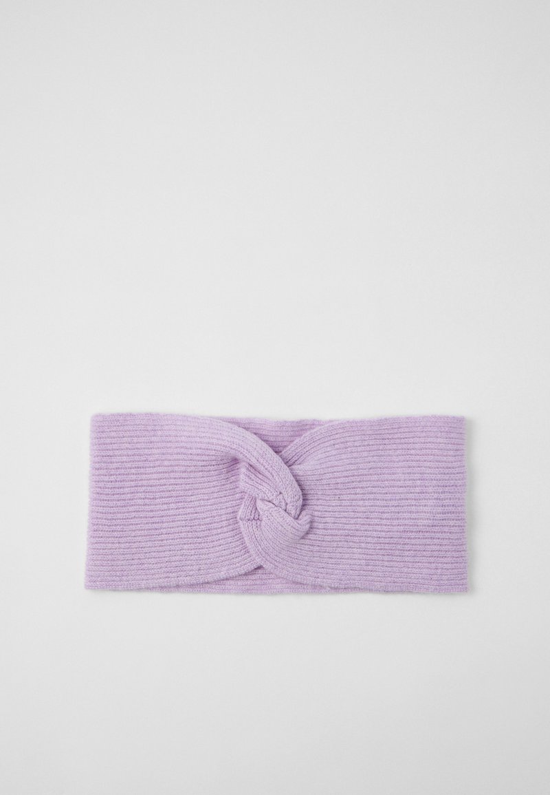 Knotty fejpánt puha levendula színű kötött anyagból. Bordás textúrával és elől csavart dizájnnal rendelkezik. Kb. 22 cm széles.