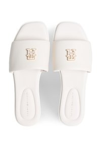Άσπρα σανδάλια με φλάτ σχεδιασμό, φαρδιά τιράντα, χρυσό λογότυπο και υφή στην επιφάνεια για άνεση. Ομαλή επιφάνεια υλικού.