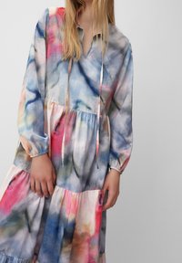 Flerfärgad klänning med lång ärm och lagerdesign, med ett abstrakt mönster i blått, rosa och beige samt dragsko vid halsen.