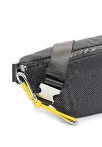 Coin d'un sac en tissu noir texturé avec une fermeture éclair argentée, une boucle métallique, une sangle noire et un tire-zip en cuir jaune à extrémité argentée.