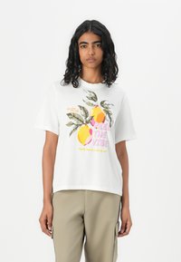 Hvid bomulds t-shirt med et farverigt citrontryk og teksten "Feel the Vibe." Korte ærmer og afslappet pasform.