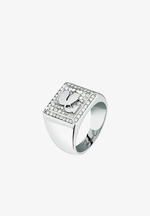 Zilverkleurige ring met een vierkant gezicht, voorzien van een verhoogd ontwerp en omringd door strass-steentjes. Gladde, glanzende afwerking; gegraveerde handtekening aan de binnenzijde.