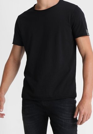 Sort kortærmet t-shirt med rund hals, lavet af blødt stof. Indeholder en lille logodetalje på den ene ærme. Stylet med mørke jeans.