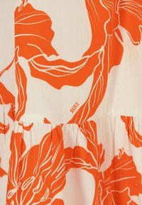 Vitt tyg med stora orangea abstrakta blommönster och subtila veck, med varumärket "BIZUU" tryckt i små bokstäver.