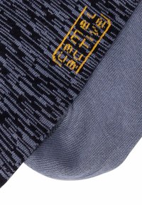 Skarpetki w ciemnoniebieskim kolorze z teksturowanym wzorem, z jasnoniebieską piętą i palcami oraz żółtym haftowanym logo.