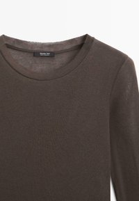 Dark brown knit long-sleeve shirt with a crew neckline. Features delicate texture and minimal branding on the inner label. Straight cut.