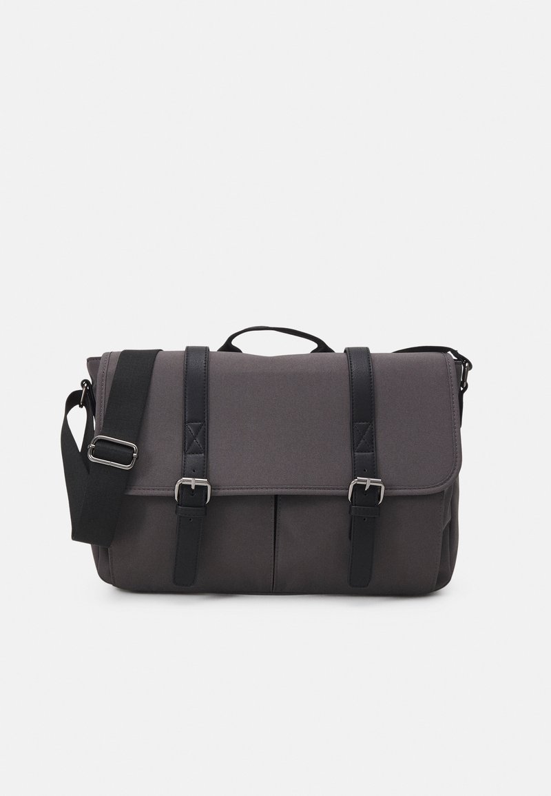 Borsa a tracolla grigia in tessuto con pattina, due tracolle nere e accessori in argento. Include una maniglia superiore e una tracolla regolabile.