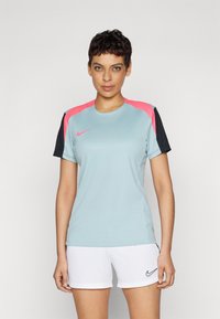Camiseta atlética azul clara con acentos en rosa y negro en los hombros. Fabricada con material transpirable, con cuello redondo, mangas cortas y diseño ajustado.
