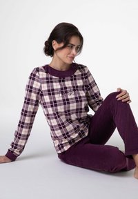 Top a maniche lunghe a quadri viola con una finitura morbida e testurizzata, abbinato a pantaloni viola. Il top presenta un delicato ricamo.