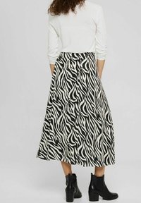 Maxi rok in zwart-wit zebra print, gemaakt van lichtgewicht stof, met een vloeiende ontwerp en gecombineerd met zwarte enkellaarsjes.