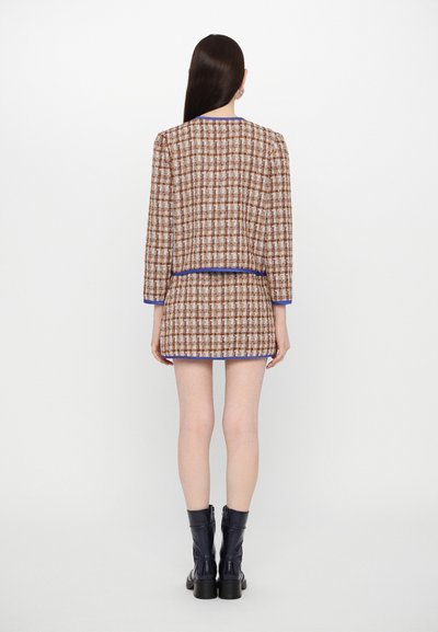 Bruine en crèmekleurige geblokte tweed blazer- en rokset, met blauwe rand, van achteraf weergegeven. Heeft lange mouwen en een rechte snit.