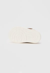 Hnedé semišové tenisky s textúrovaným povrchom. Biela gumová podrážka s obľúbeným vzorom a značkovaním. Minimalistický dizajn.