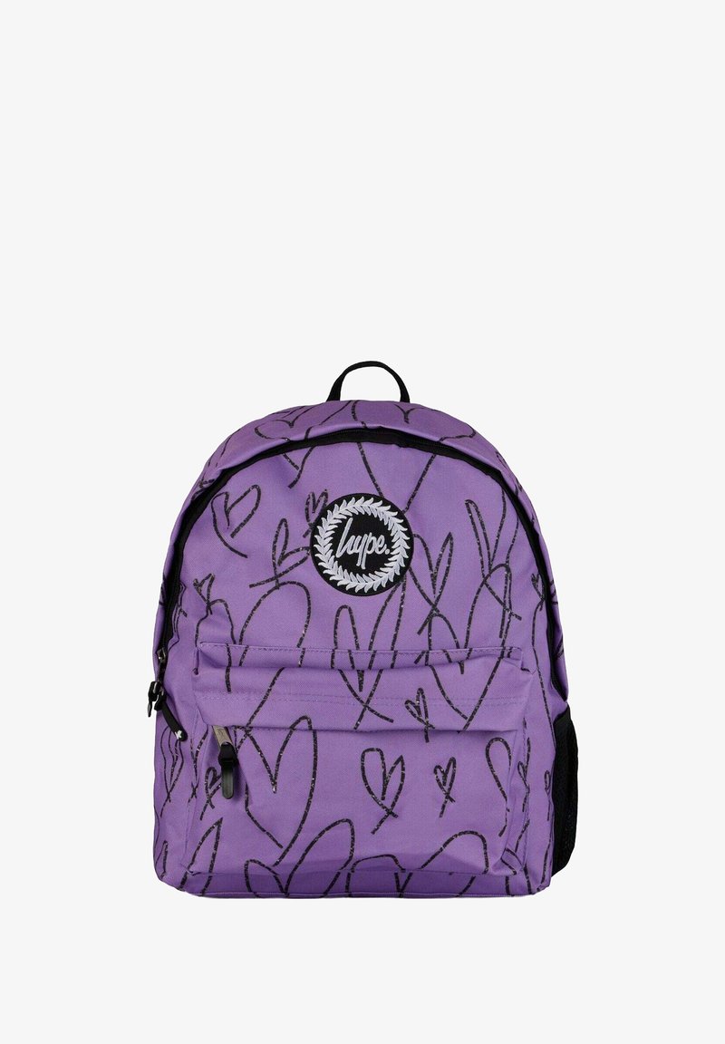Violetti reppu, jossa on mustia sydänkuvioita, etupokki vetoketjulla ja pyöreä logo-patch. Valmistettu kestävästä kankaasta, jossa on säädettävät hihnat.