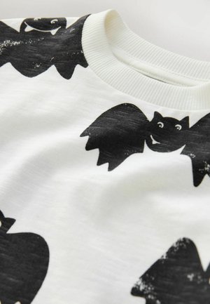 Witte stoffen T-shirt met een zwart vleermuizenpatroon. Ronde halslijn met geribbelde rand en een zachte, iets gestructureerde oppervlakte.