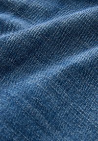 Sügisene denim kangas sügavas sinises, millel on tekstuur, nähtavad kootud mustrid ja peened värvimuutused. Pehme ja paindlik.