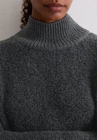 Czarny szary, teksturowany sweter z golfem wykonany z miękkiego materiału, z prążkowanym dekoltem, z aksamitną, przypominającą boucle powierzchnią.