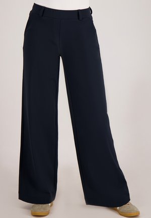 Wijde broekspijpen in donker marineblauwe stof met een gladde textuur. Voorzien van een getailleerde tailleband en zijzakken, met een comfortabele pasvorm.